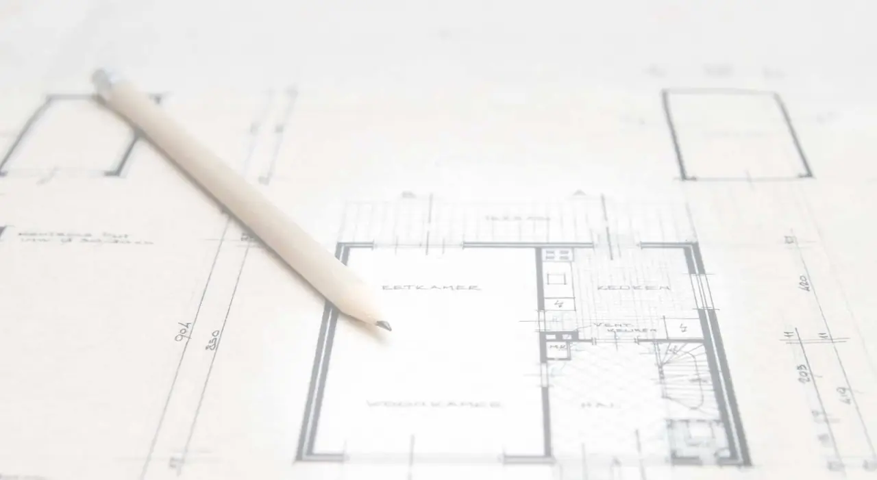 A pencil resting on printed house floor plans